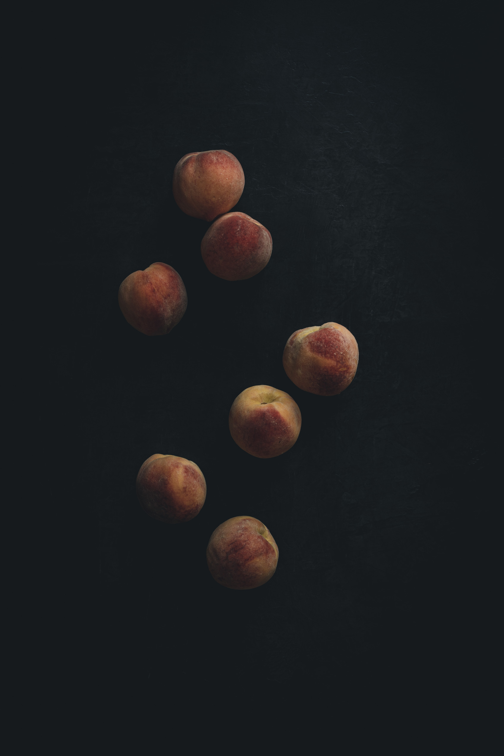Peaches on a black background from the Moody Food series by John Robson Photography