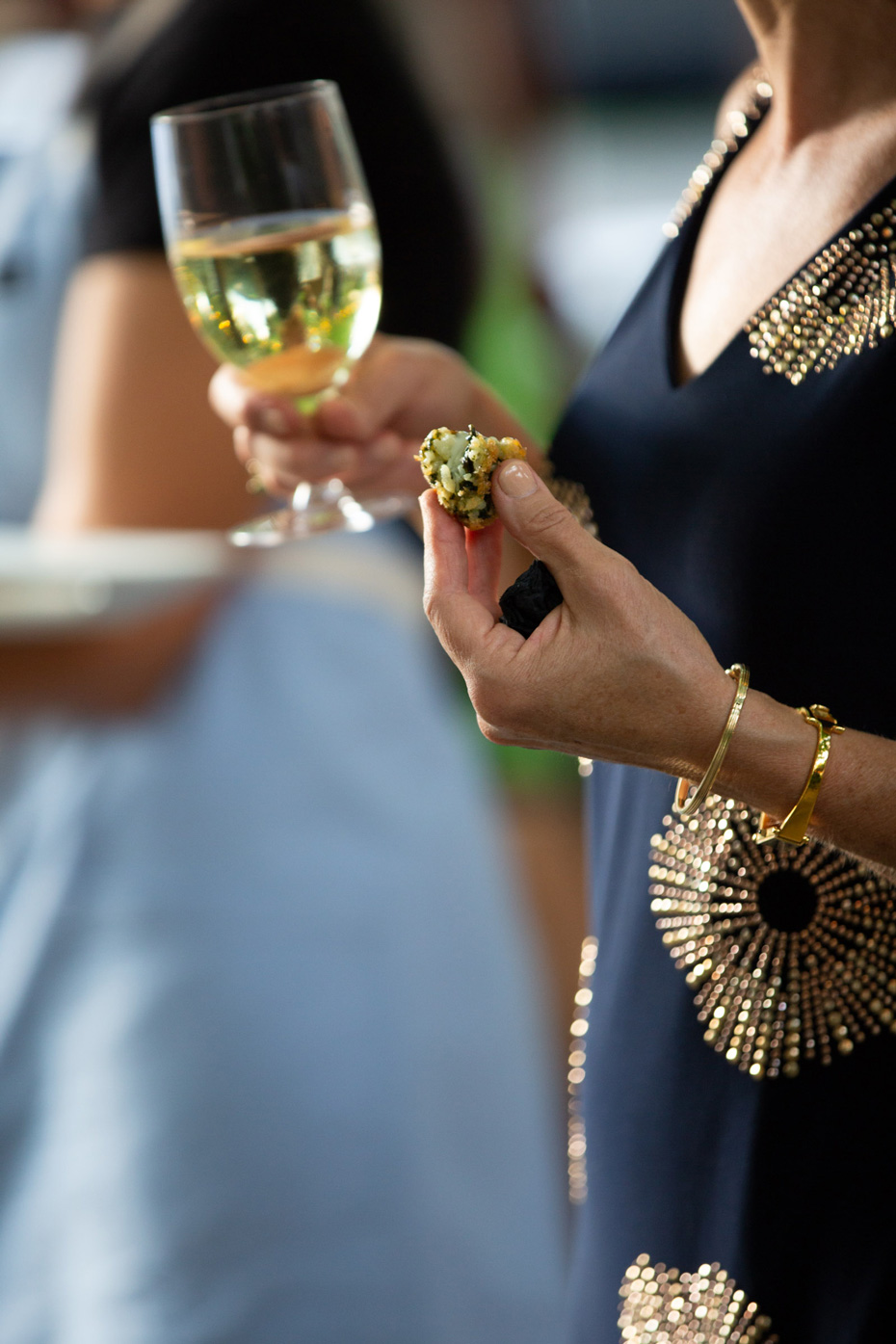 Woman eating an arancini at a wedding in Fort Collins Colorado - John Robson Photography
