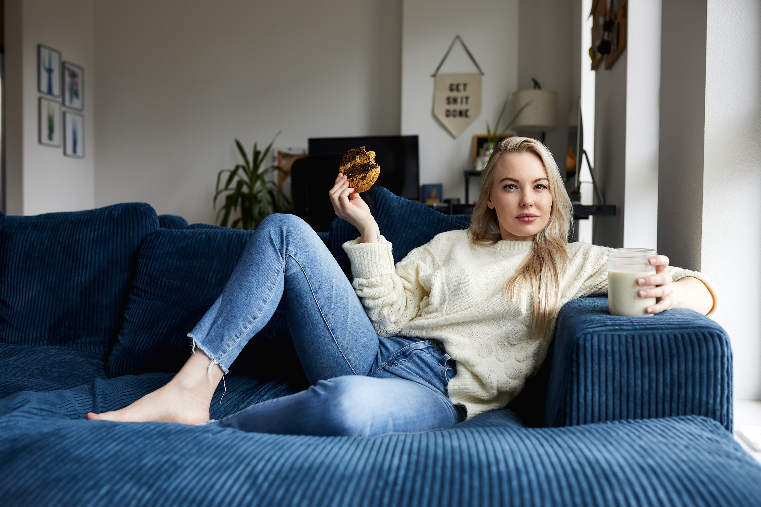 Portrait of lifestyle model eating cookies on a couch - John Robson Photography