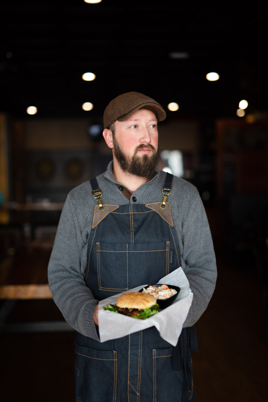 Portrait of service industry worker holding an entree at William Oliver