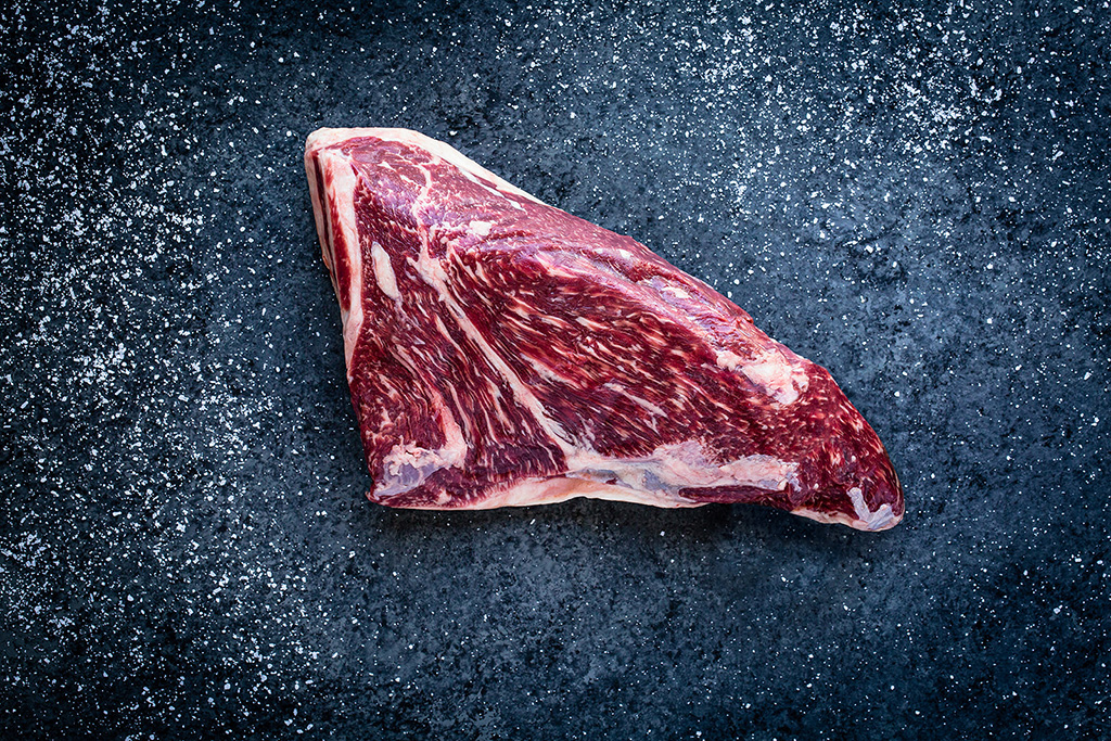 Raw tri tip steak on a dark background - John Robson Photography