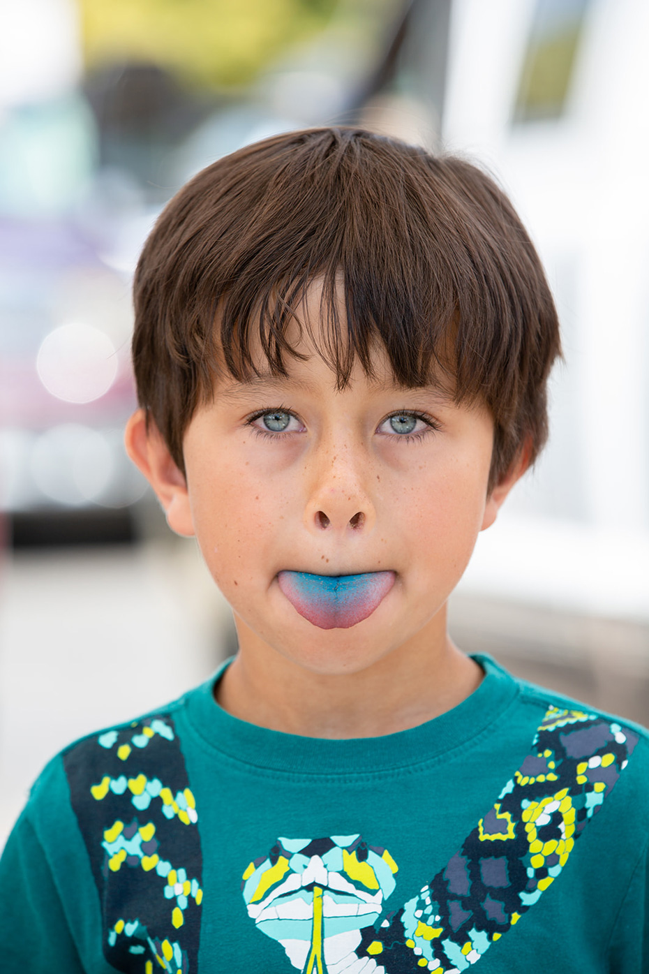 Boy sticking out a blue tongue at a farmers market in Fort Collins, Colorado - John Robson Photography