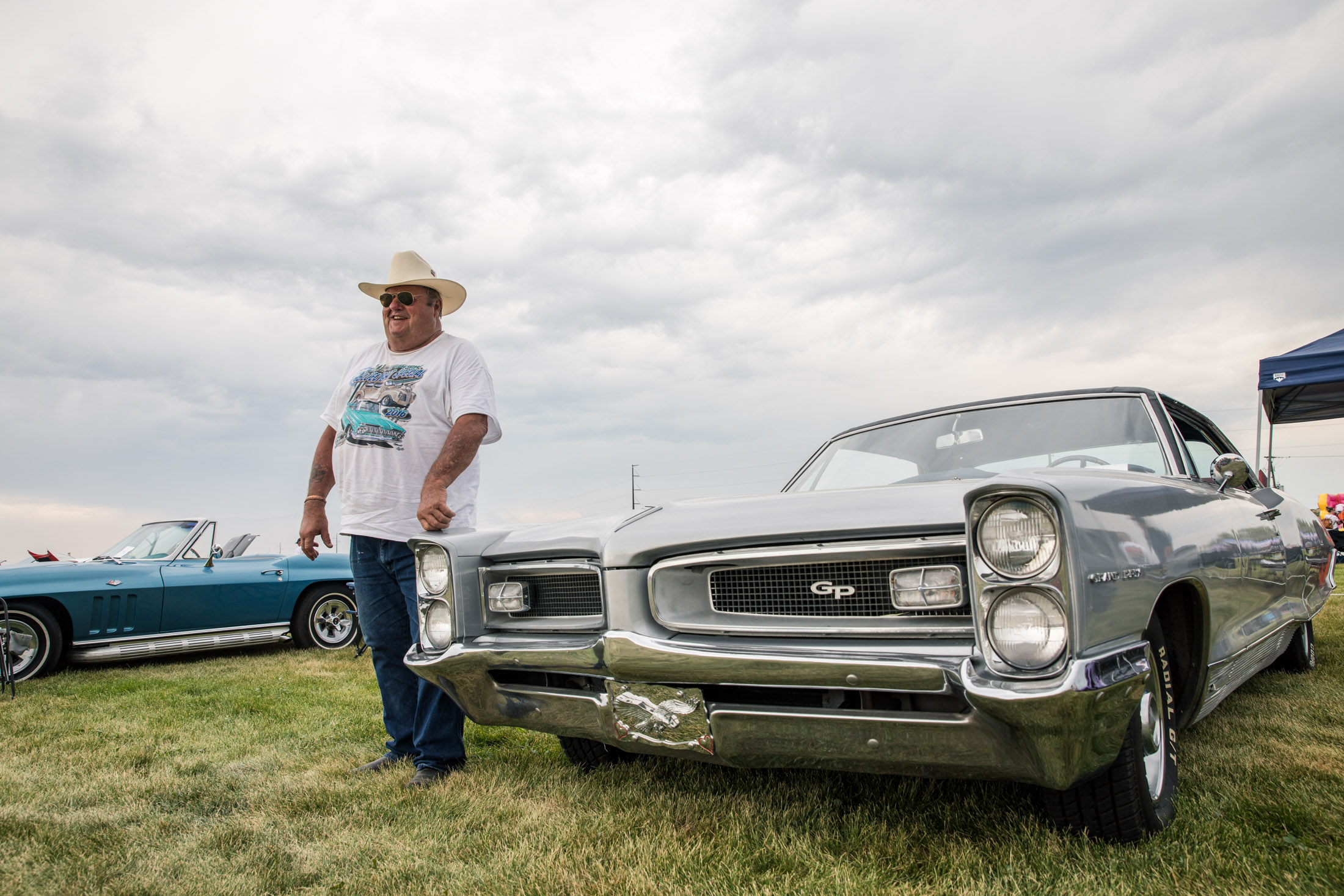 Man standing by a silver vintage car at the NOCO Car Show in Severance, Colorado - John Robson Photography