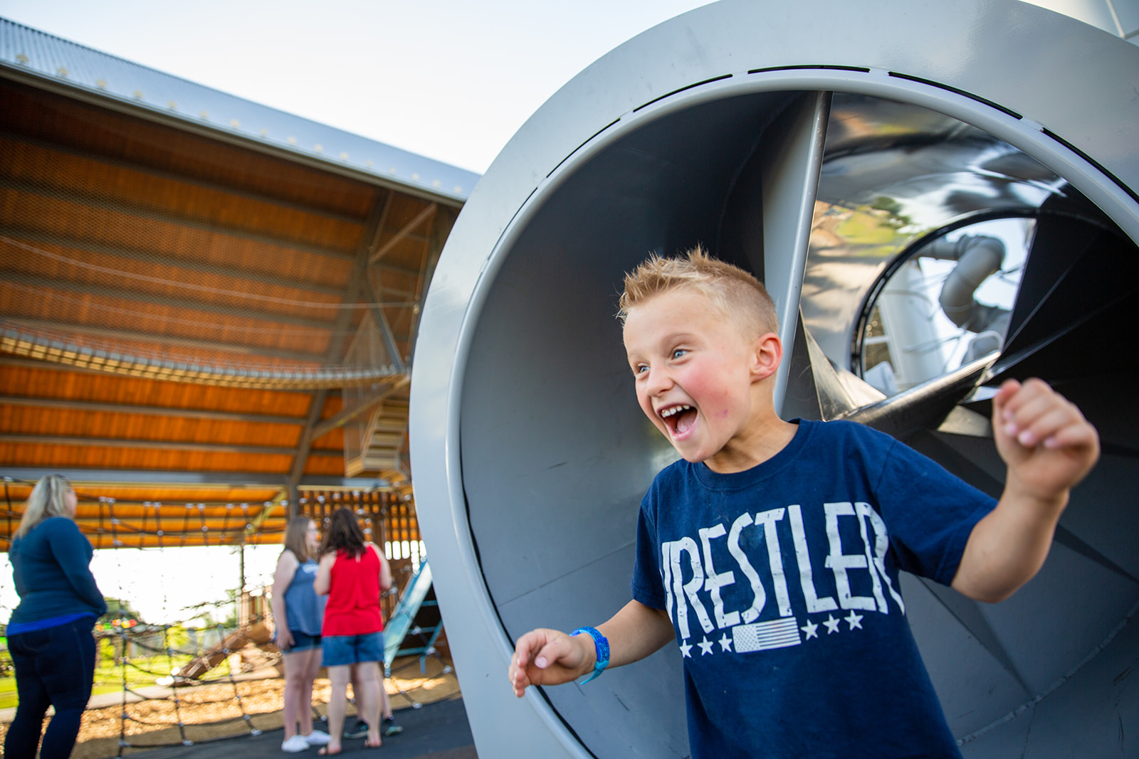 Young boy excitably playing on playground equipment at Twin Silo Park in Fort Collins - John Robson Photography