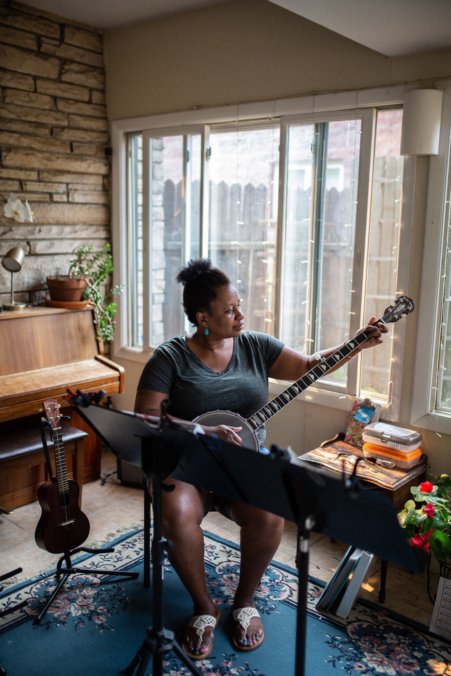 Musician, Saja Butler,  playing a banjo in her home  - John Robson Photography