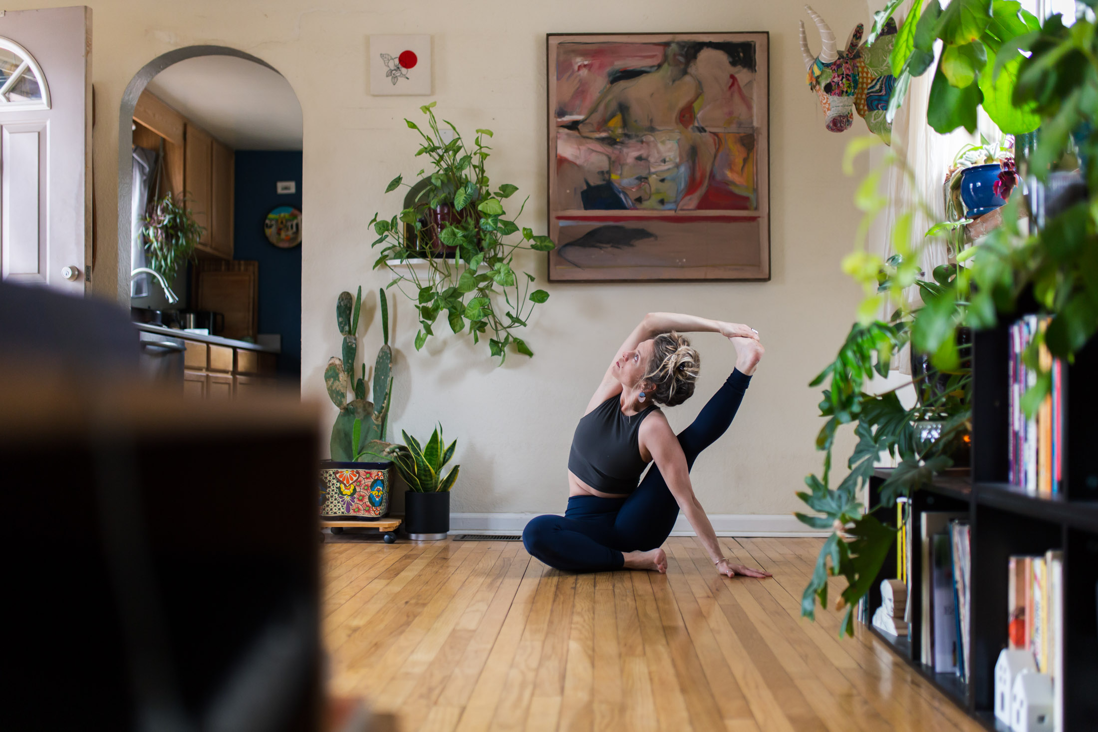 Lifestyle portrait of a yoga instructor, Libby Lyons, doing a pose in her living room - John Robson Photography
