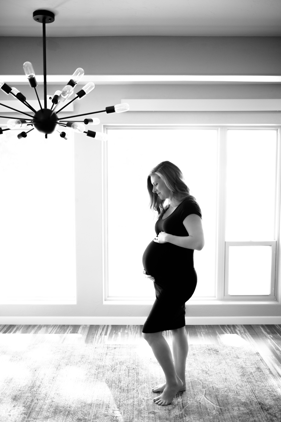 Black and white maternity portrait of a woman in front of a window - John Robson Photography