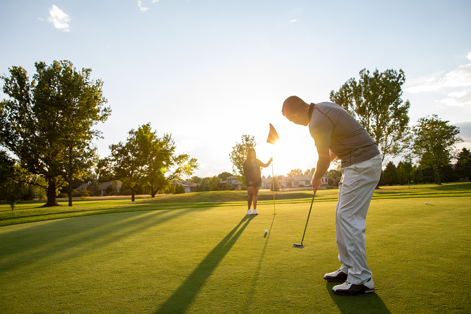 Golfers putting on a green at Collindale Golf Course in Fort Collins at sunset - John Robson Photography
