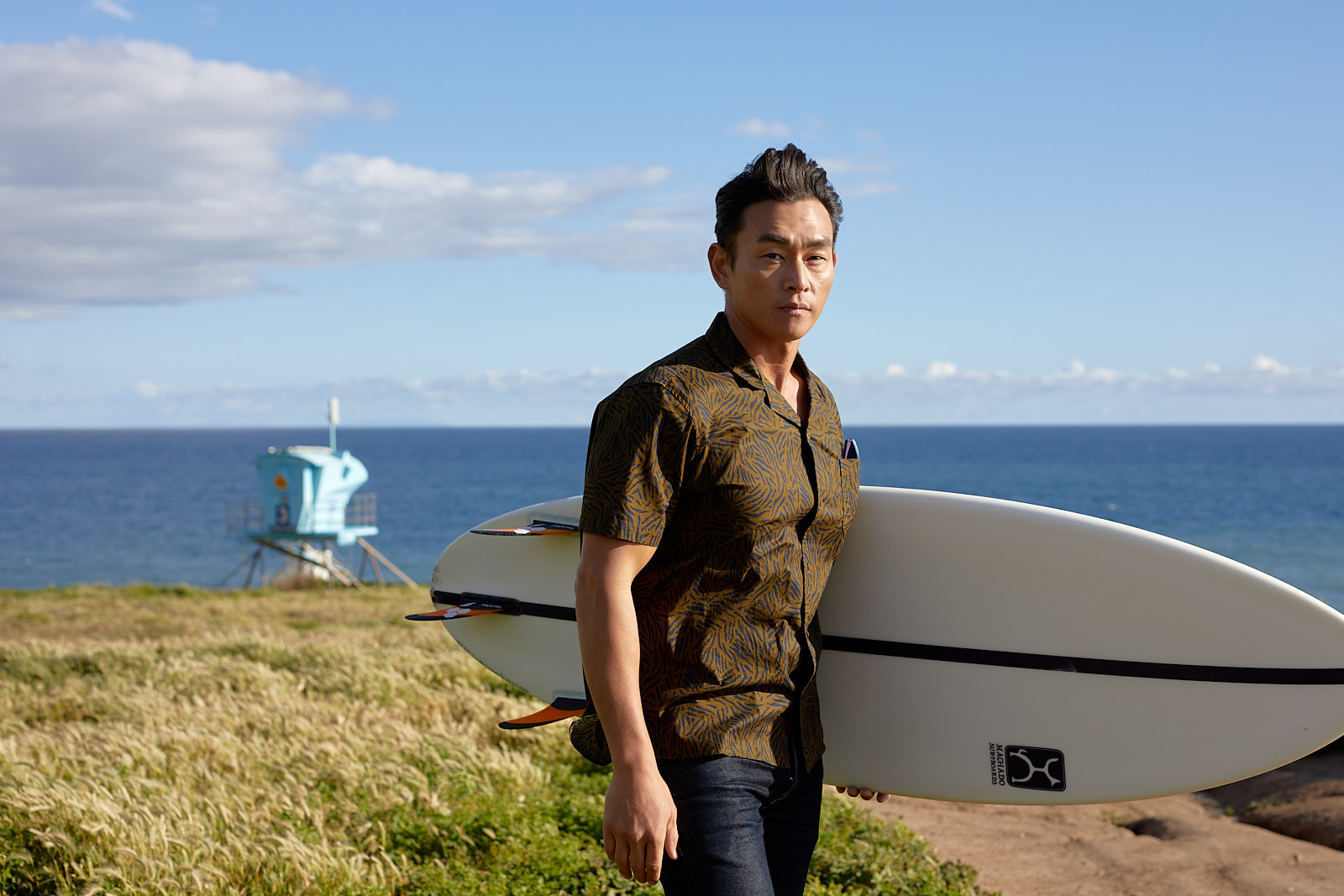 Lifestyle model holding a surfboard on the coast of Leo Carrillo State Park - John Robson Photography