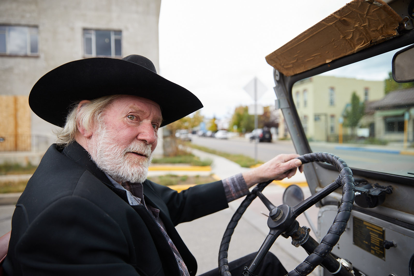Senior man with white beard driving a vintage willy jeep in Salida, Colorado - John Robson Photography