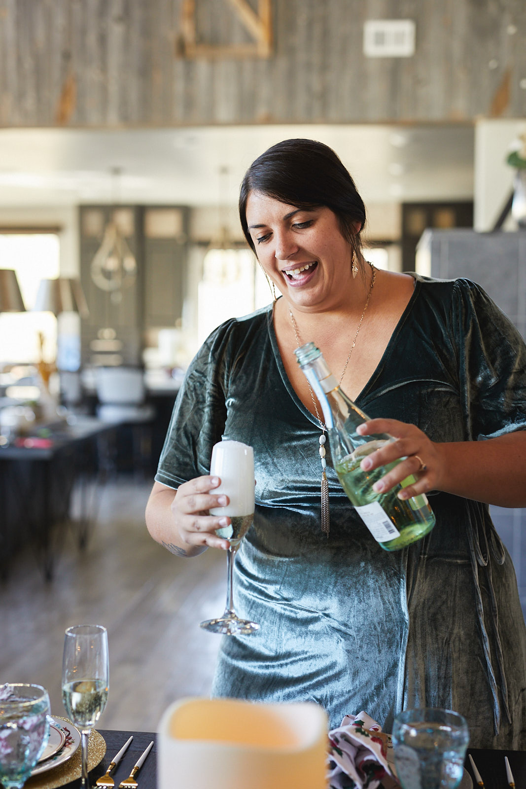 Lifestyle image of a female event planner smiling and pouring champagne - John Robson Photography