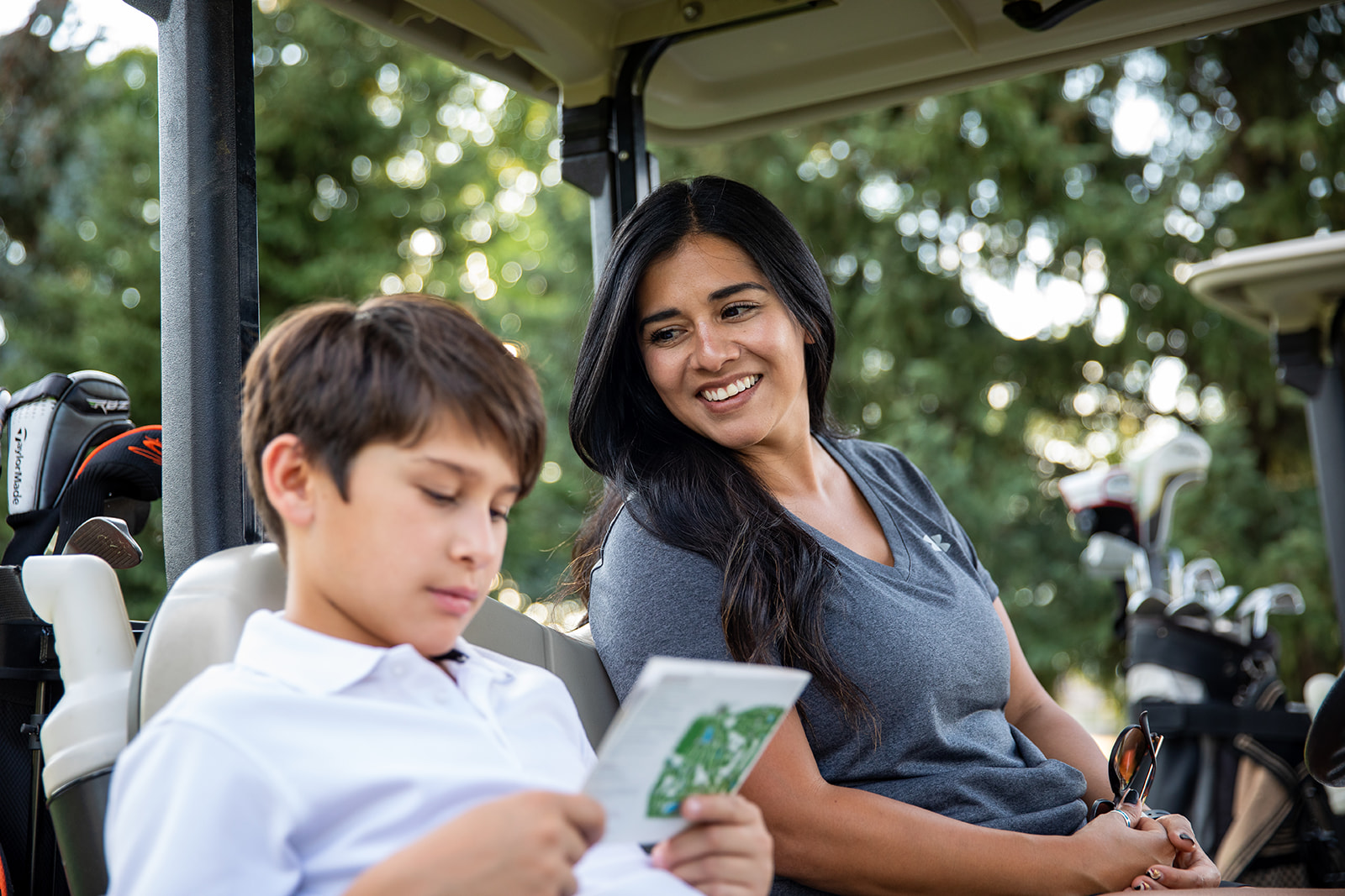 Mother and son in golf cart reviewing score - John Robson Photography