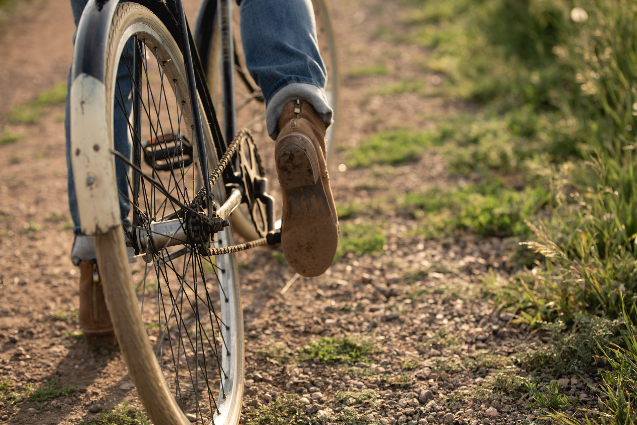 Lifestyle closeup of a woman pedaling a vintage bicycle