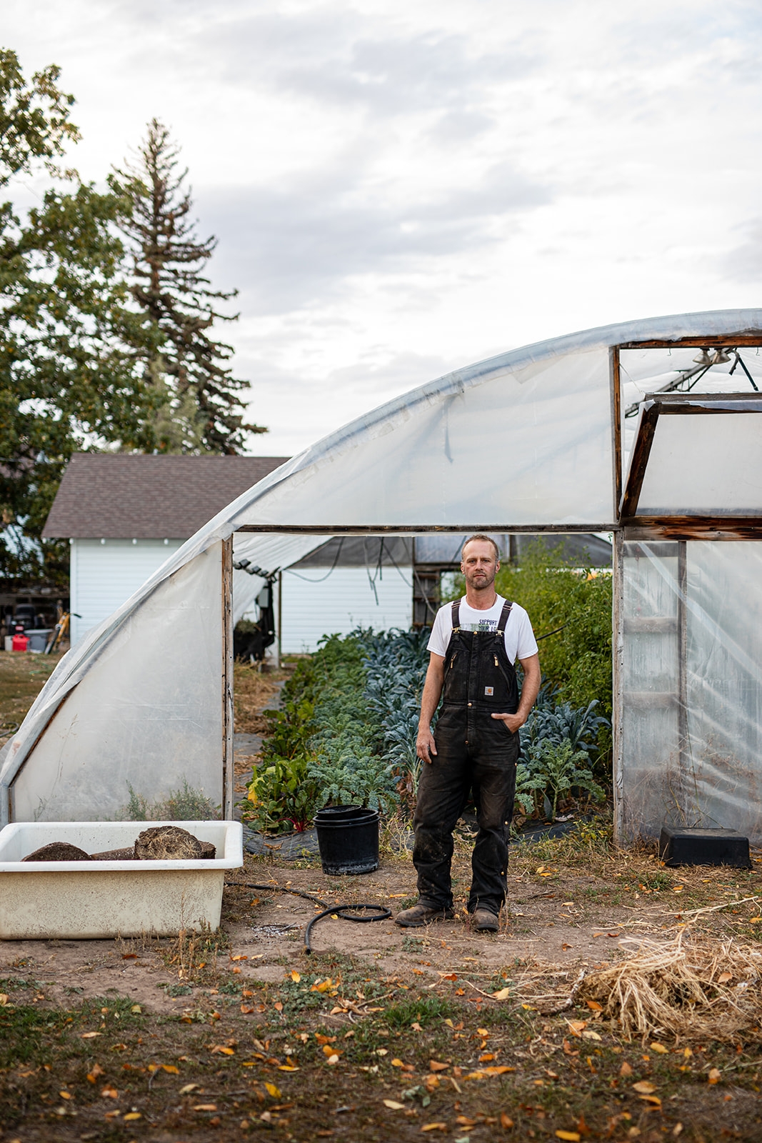Portrait of a male farmer in front of a green house - John Robson Photography