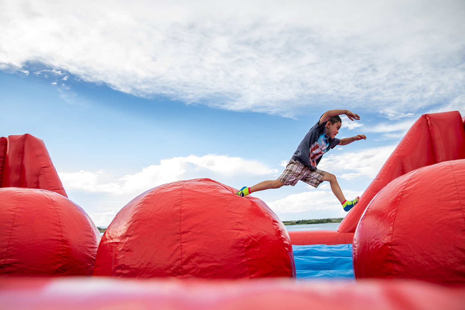 Boy jumping across an obstacle course on the fourth of July in Timnath, Colorado