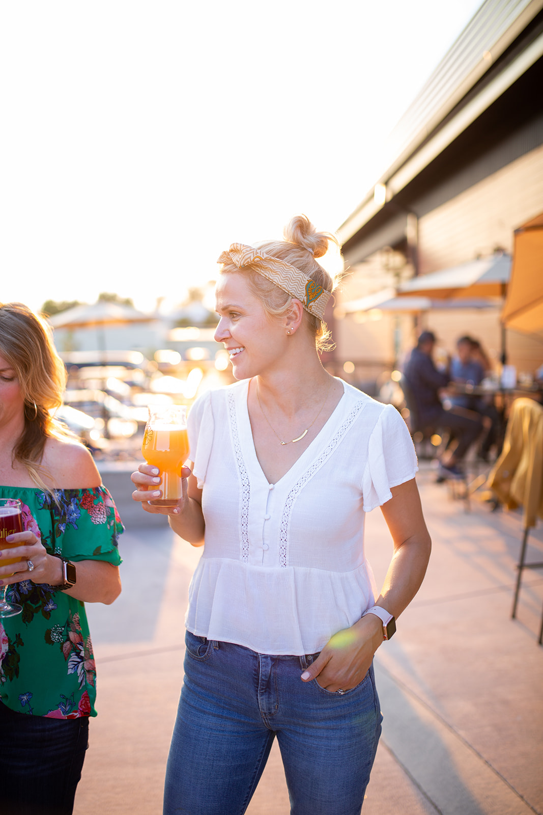 Woman drinking a beer on the patio at Peculiar Ales in Windsor, Colorado at sunset - John Robson Photography