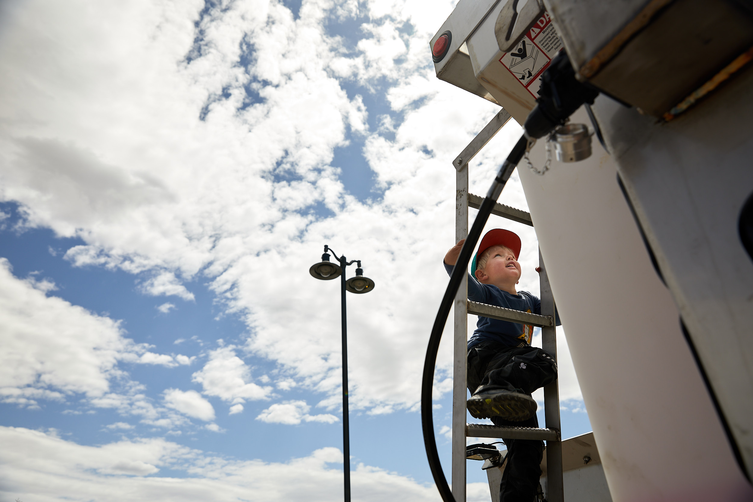 Boy climbing a vehicle at the Timnath Safety Fair - John Robson Lifestyle Photography