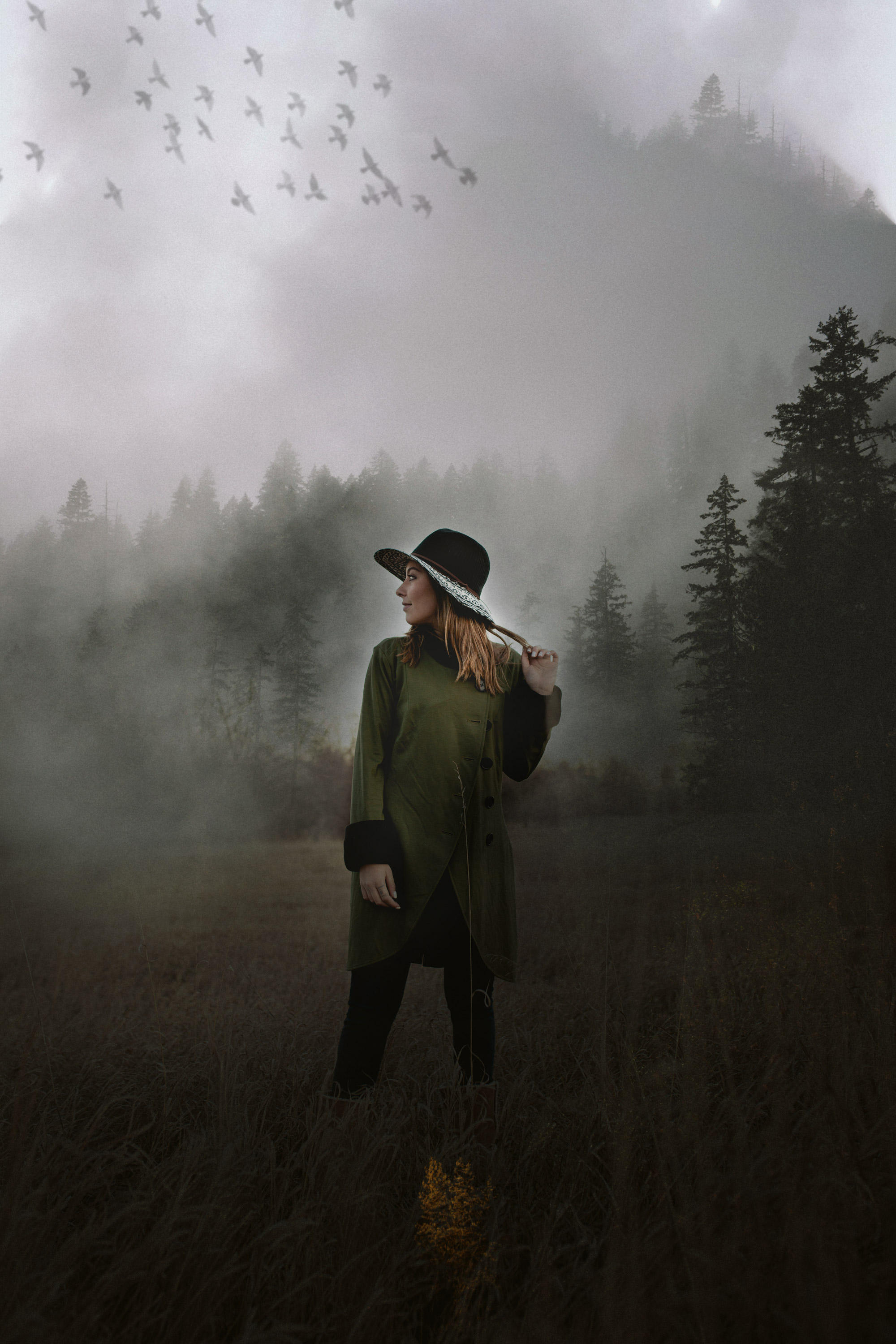 Surrealistic portrait of a woman standing in a foggy field - John Robson Photography